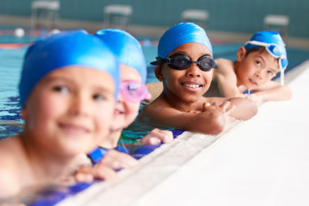 children resting at side of pool flipped